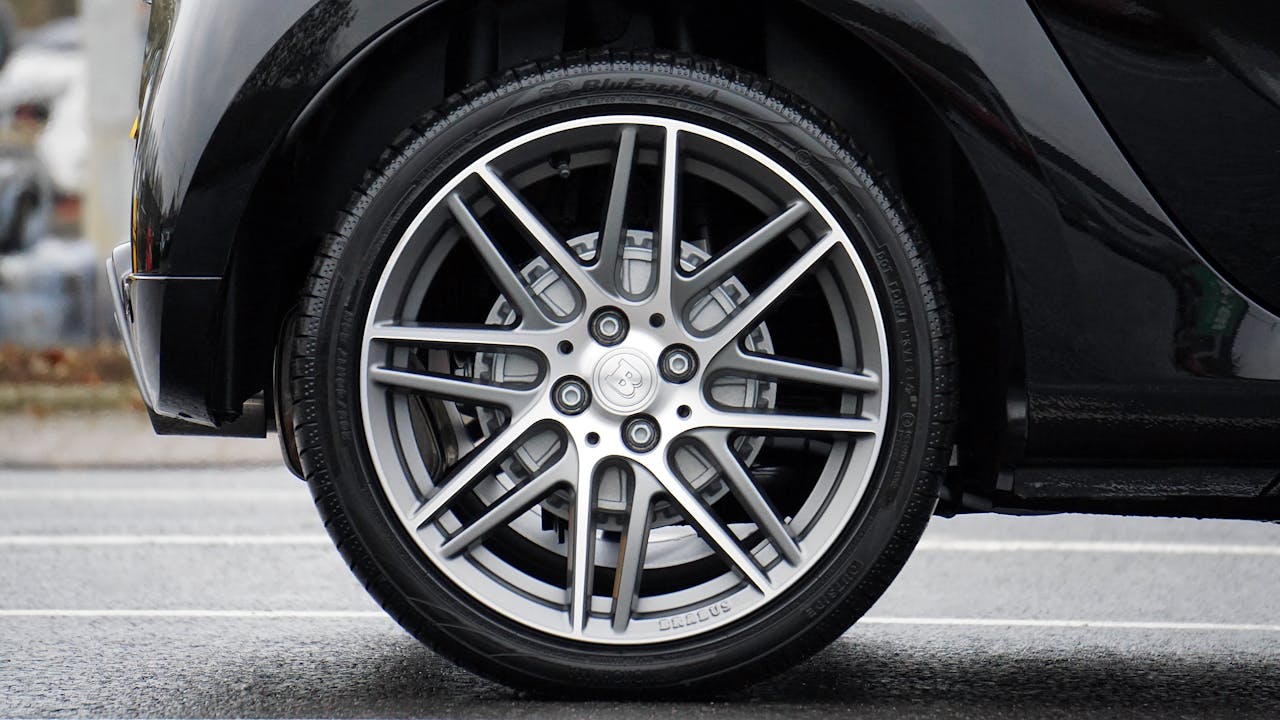 journey Detailed shot of a sleek car wheel and rim on a black vehicle, showcasing automotive design.